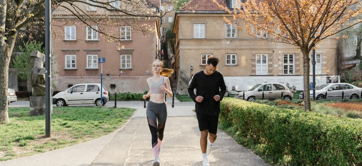 A couple jogging together in an urban park, enjoying outdoor exercise.