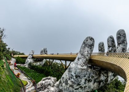 Explore the iconic Golden Bridge in Da Nang, Vietnam, held by giant stone hands amidst lush greenery.