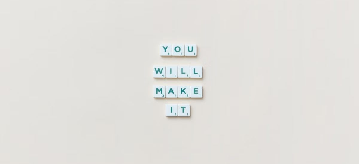 Motivational phrase 'You Will Make It' made from Scrabble tiles on a neutral background.