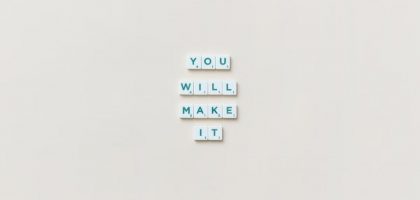 Motivational phrase 'You Will Make It' made from Scrabble tiles on a neutral background.