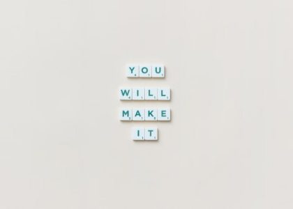 Motivational phrase 'You Will Make It' made from Scrabble tiles on a neutral background.